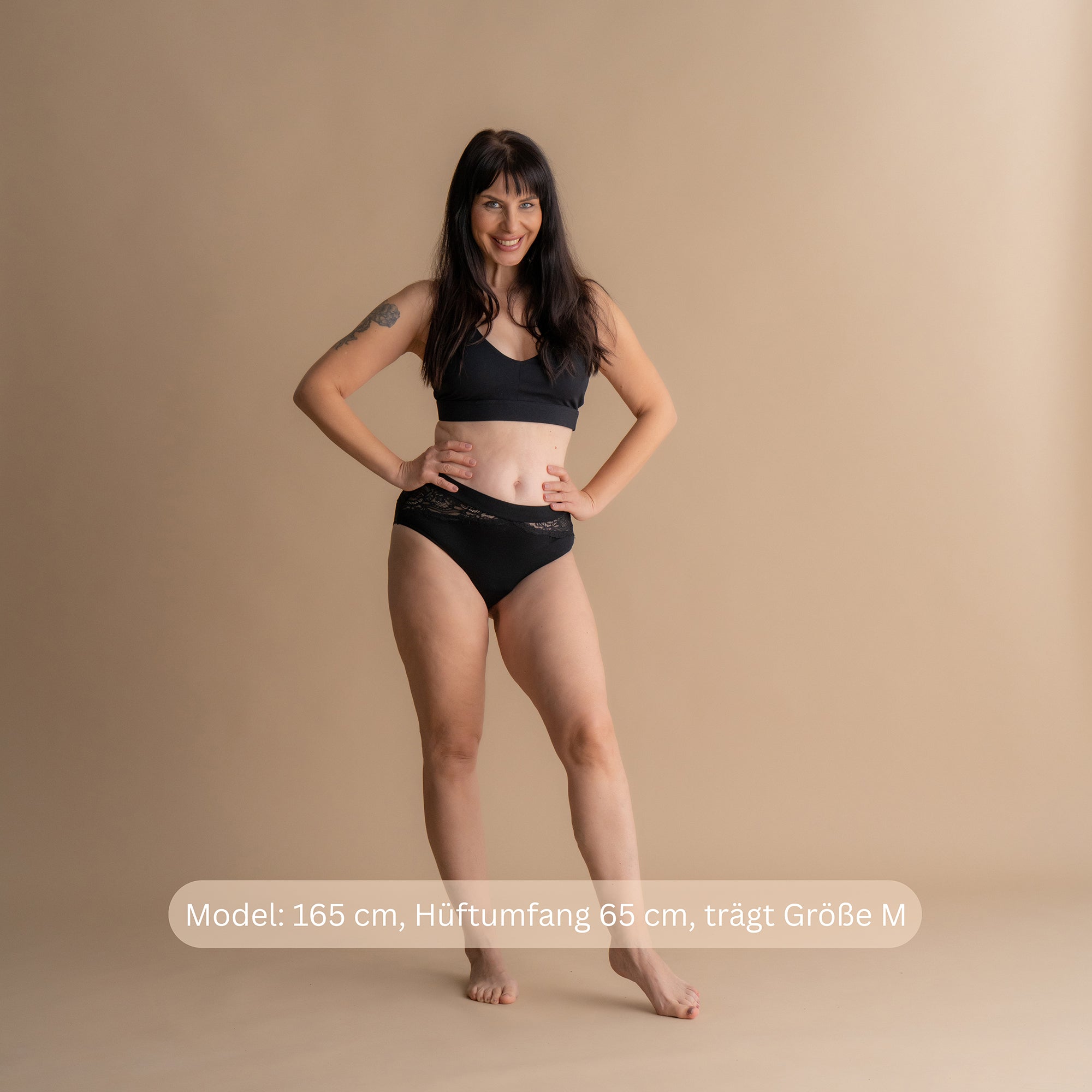 Ganzkörper-Frontansicht eines Models in der schwarzen Floena Leakproof Bamboo Lace Brief, Spitzen-Periodenunterwäsche aus Bambus, mit Spitzenbund