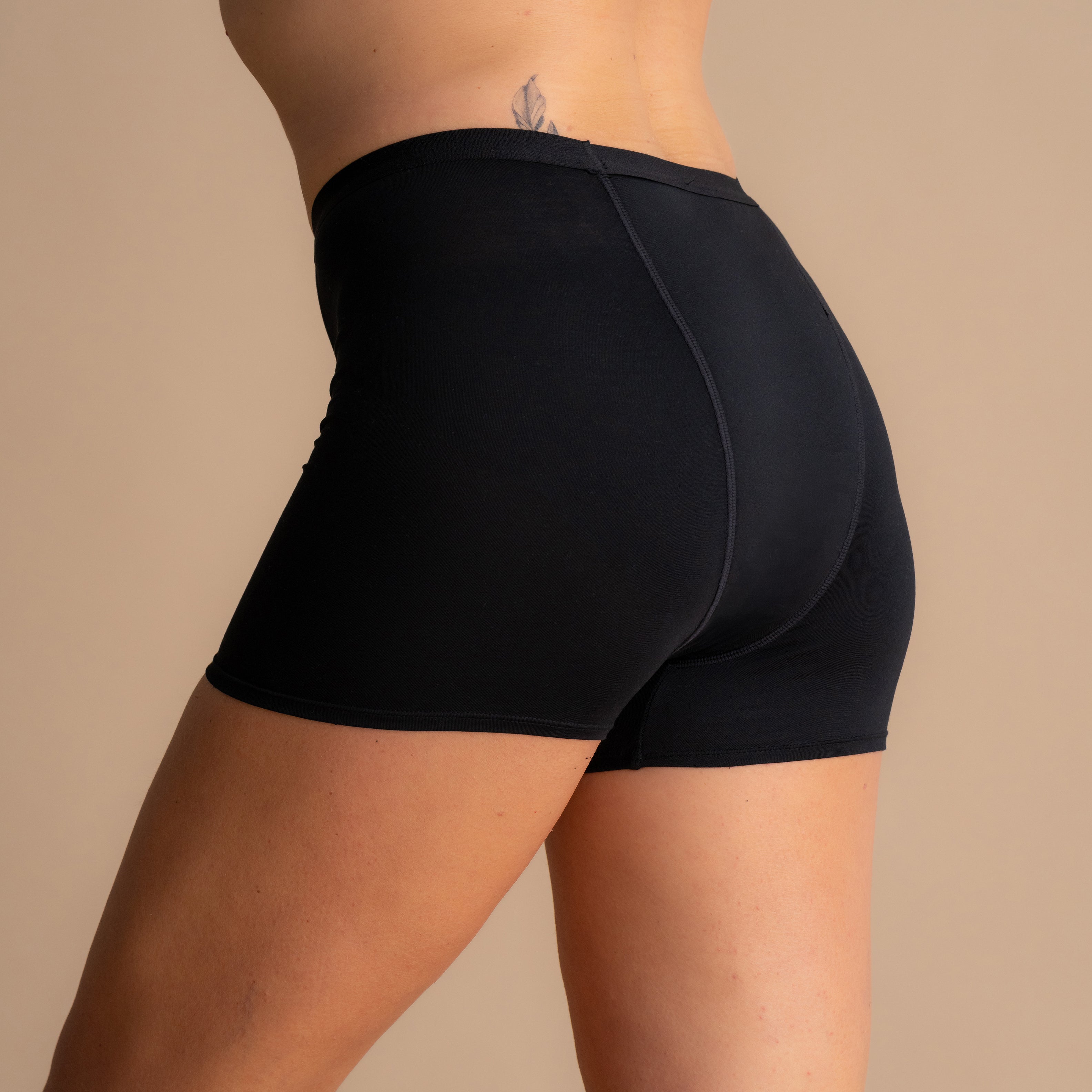 Rückansicht der schwarzen Floena Leakproof Bamboo Sleep Short Perioden-Schlafshorts am Model mit vollflächiger Passform