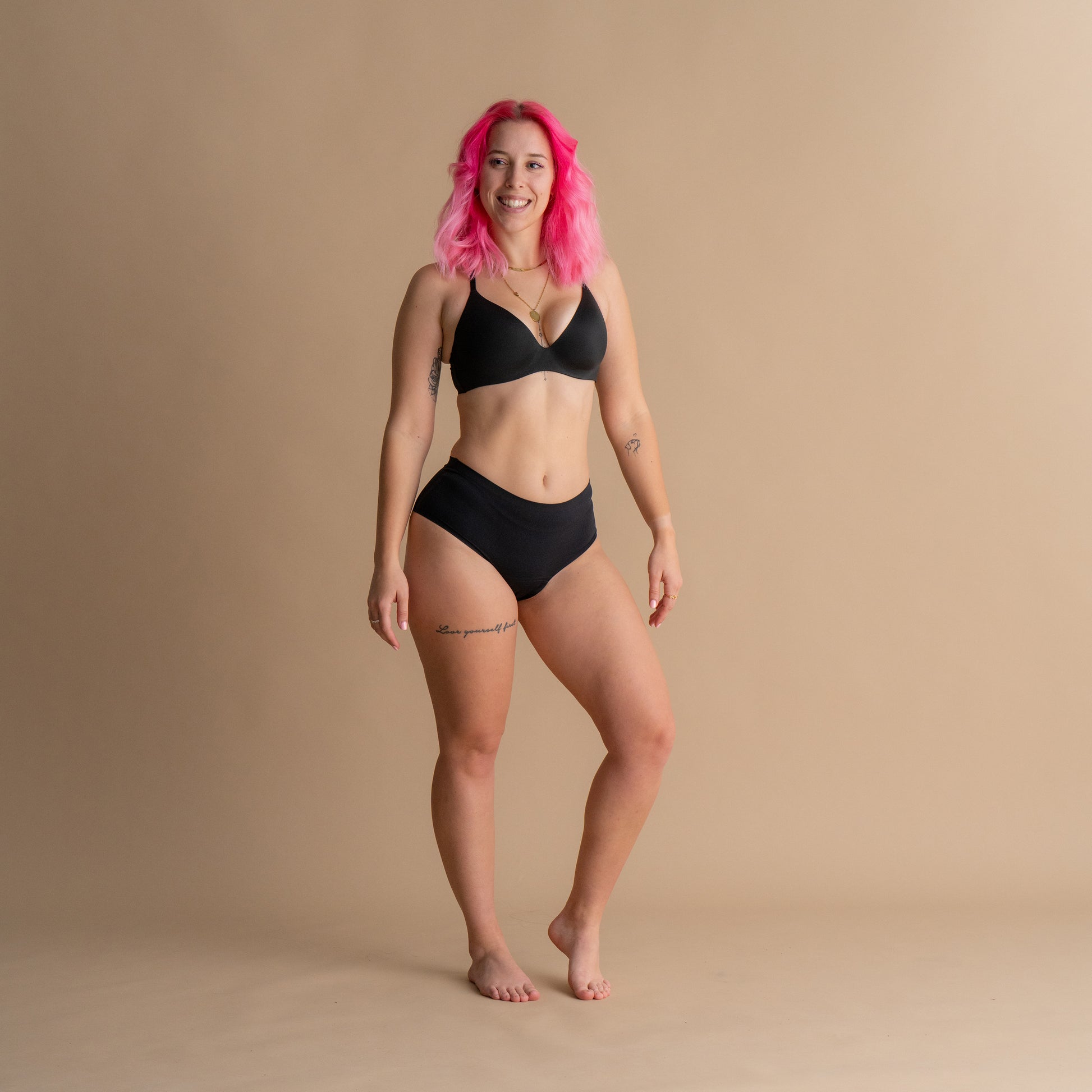 Ganzkörper-Frontansicht eines Models in der schwarzen Floena Leakproof Seamless High Waist Brief, nahtlose hoch geschnittene Periodenunterwäsche, mit schmeichelhaftem hohem Schnitt